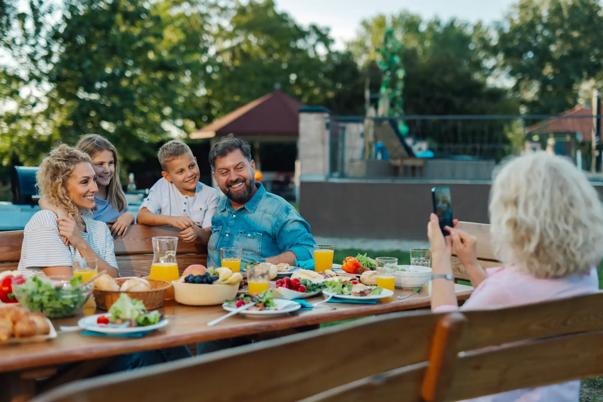 father's-Day-celebration-table-with-variety-of-food-dishes-and-smiling-family-members