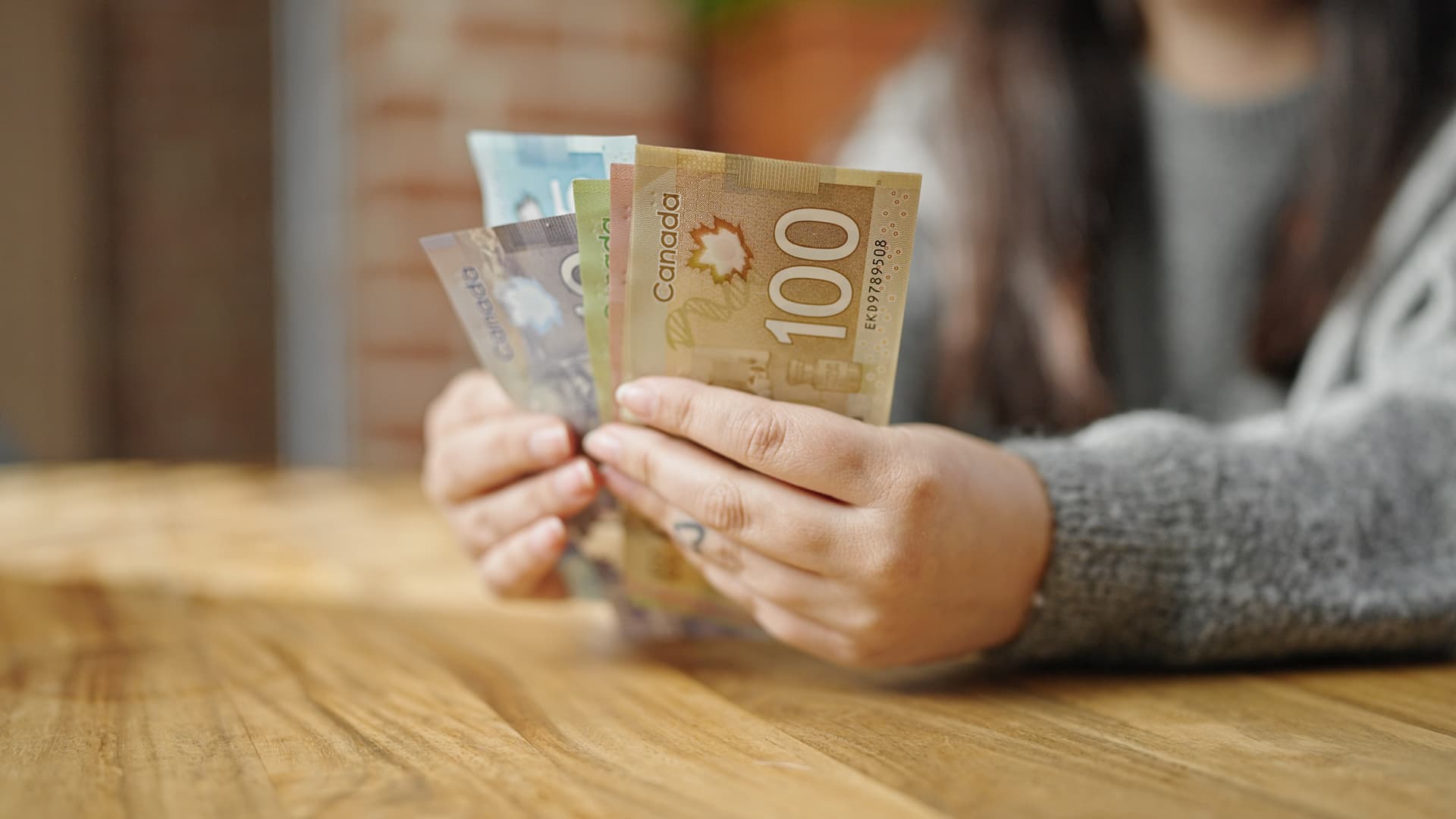 Hands of woman counting canadian dollars at room Hands of woman counting canadian dollars at room